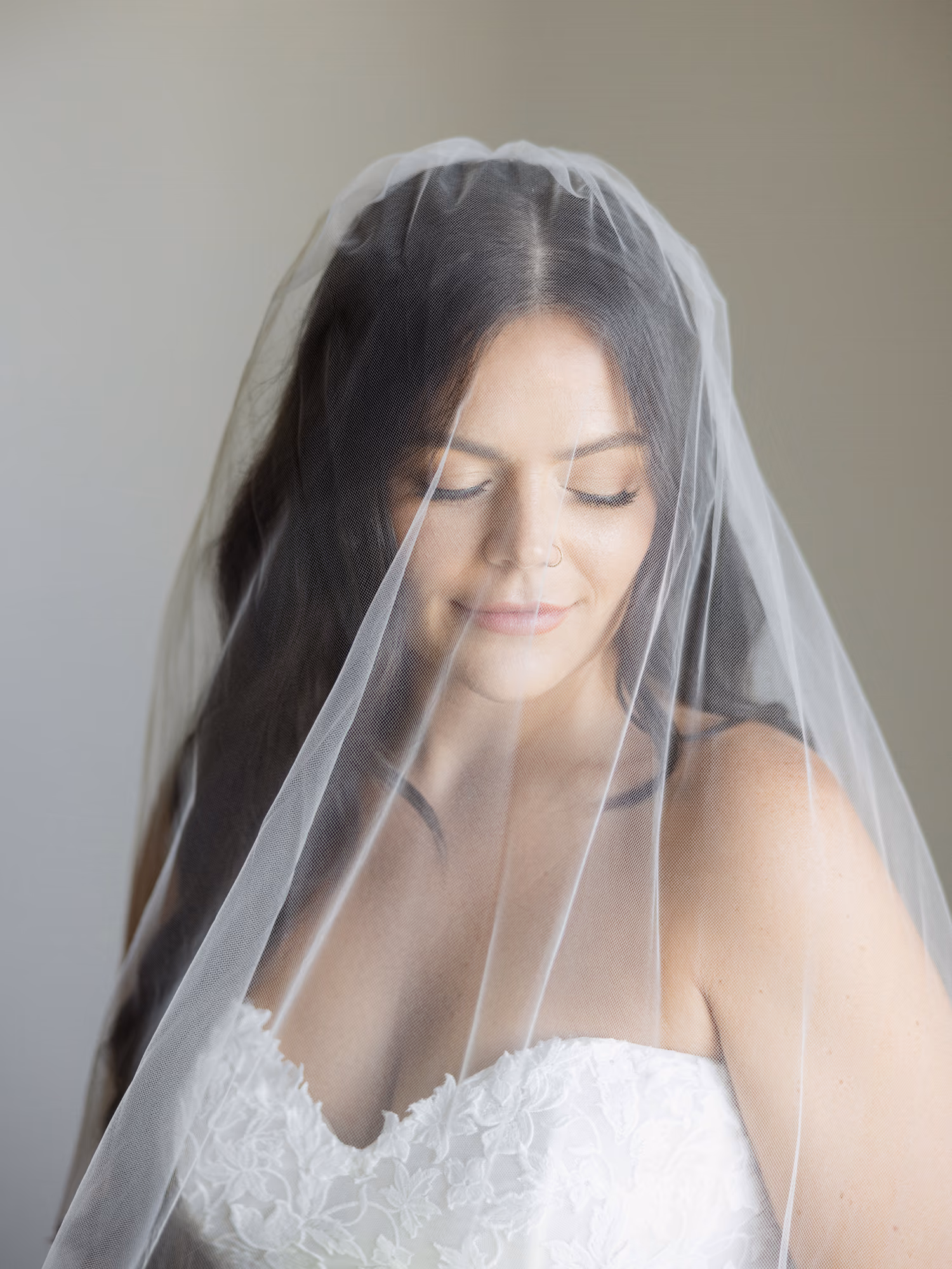 A bride under her veil, eyes closed, before the ceremony