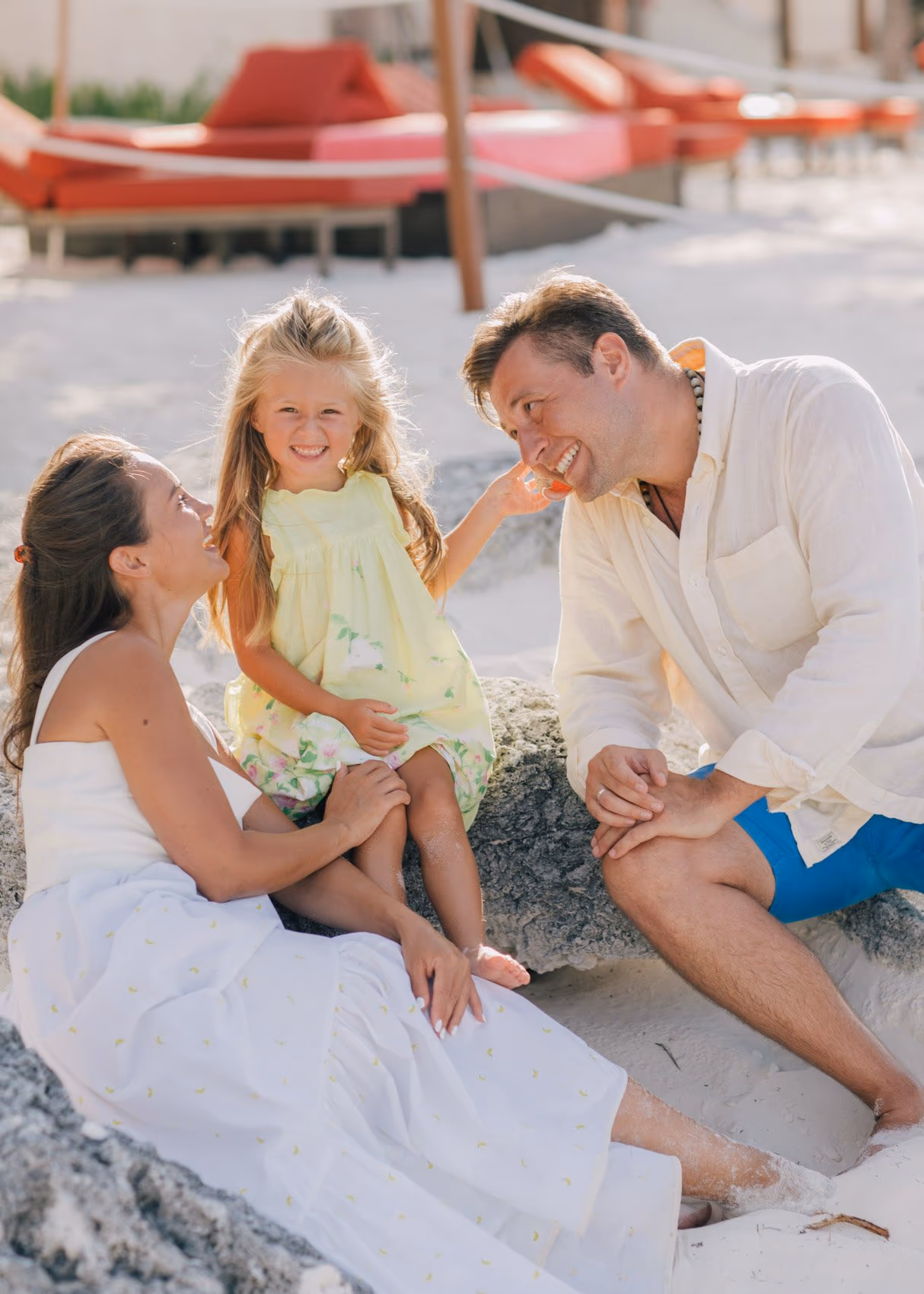 Family photoshoot in Cancun with parents and children holding hands on the beach.