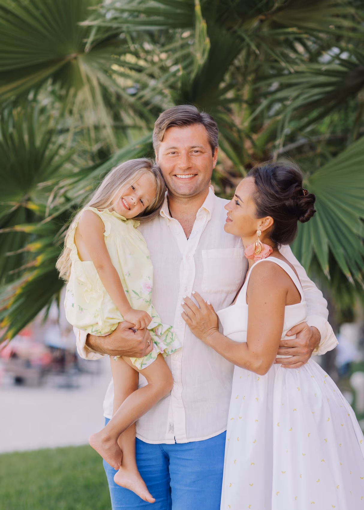 Family session in Cancun with father embracing mother and daughter happily.